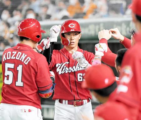 　広島・西川とタッチを交わす小園（２２年８月）