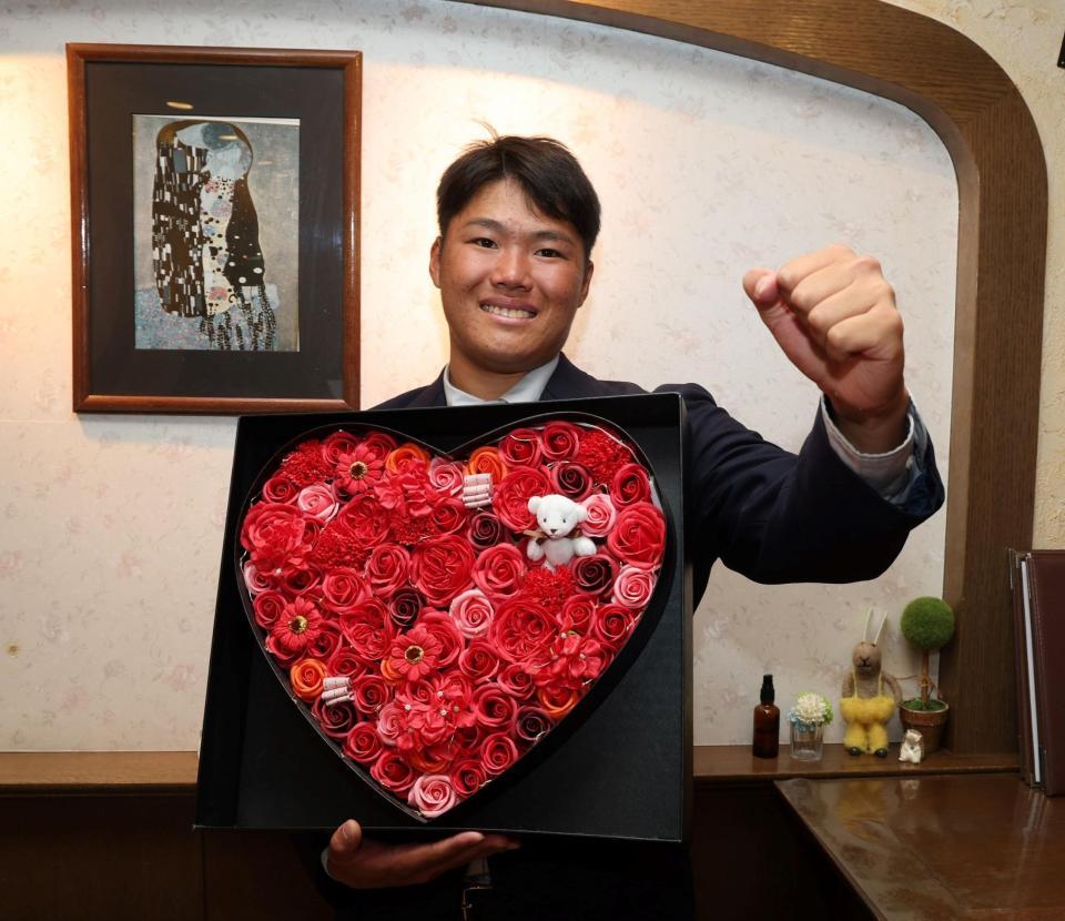 　仮契約を終え、ポーズを決める高太一（撮影・山口登）