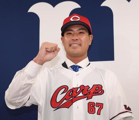 　入団会見でガッツポーズを決める内間（撮影・田中太一）