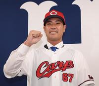 　入団会見でガッツポーズを決める内間（撮影・田中太一）