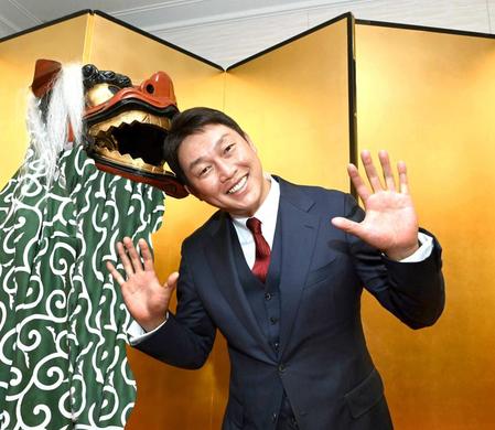 　獅子舞に頭をかまれ、笑顔を見せる新井監督