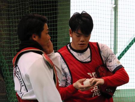 　ブルペンでの投球練習後に意見交換するドラフト３位・滝田（右）と持丸＝撮影・畠山賢大