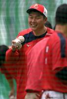 　打撃練習後に球拾いをする新井監督（撮影・市尻達拡）