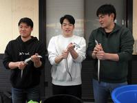 　うなぎのつかみ取りをする（左から）高、滝田、赤塚
