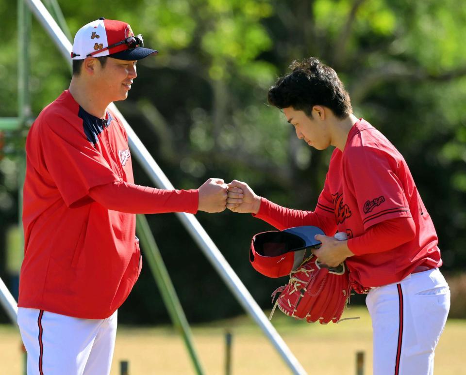 　笑顔の新井監督とグータッチする常広