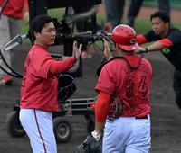 　シート打撃登板を終え、高木とタッチを交わす栗林（撮影・市尻達拡）