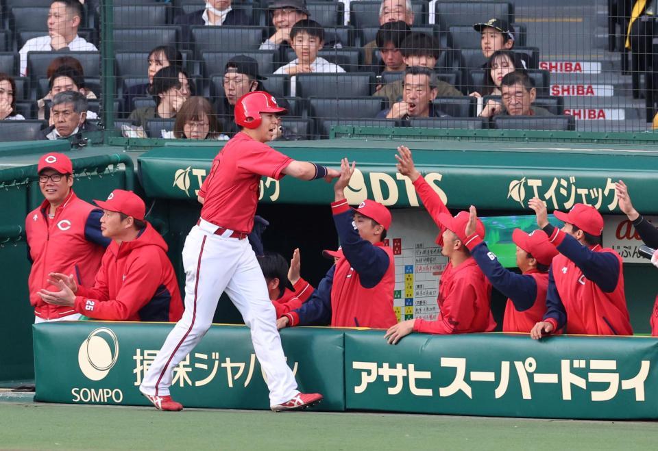 　１回、生還した野間（中央）を迎える広島ナイン（撮影・山口登）