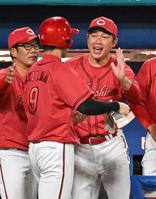 　６回、野間の適時打で生還した秋山（中）を迎える新井監督（右）