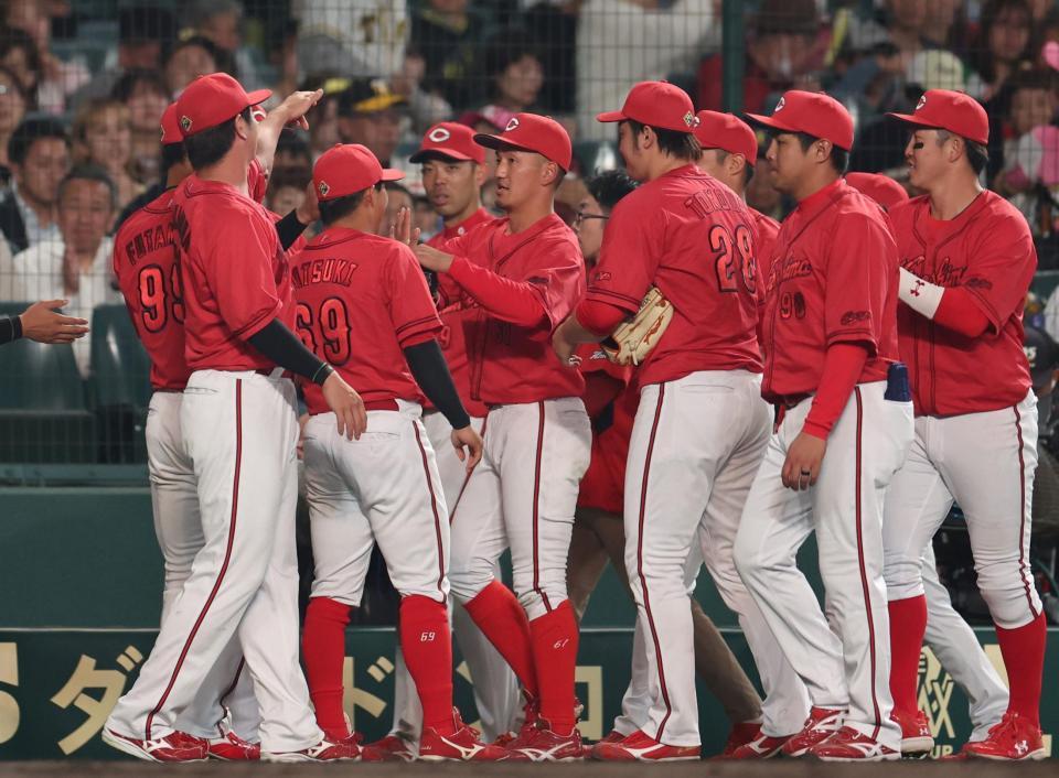 　４回、佐藤輝の邪飛を好捕した遊撃手の矢野（中央）はナインの出迎えを受ける（撮影・中田匡峻）