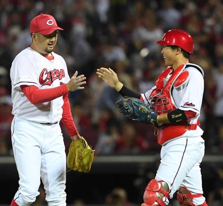 　試合終了後、中崎（左）とタッチを交わす石原（撮影・市尻達拡）