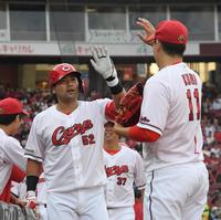 　１回、左越え２ランを放った末包は九里とタッチを交わす（撮影・市尻達拡）