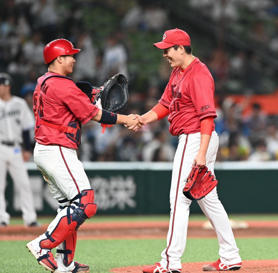 　坂倉（左）と握手を交わす九里（撮影・園田高夫）