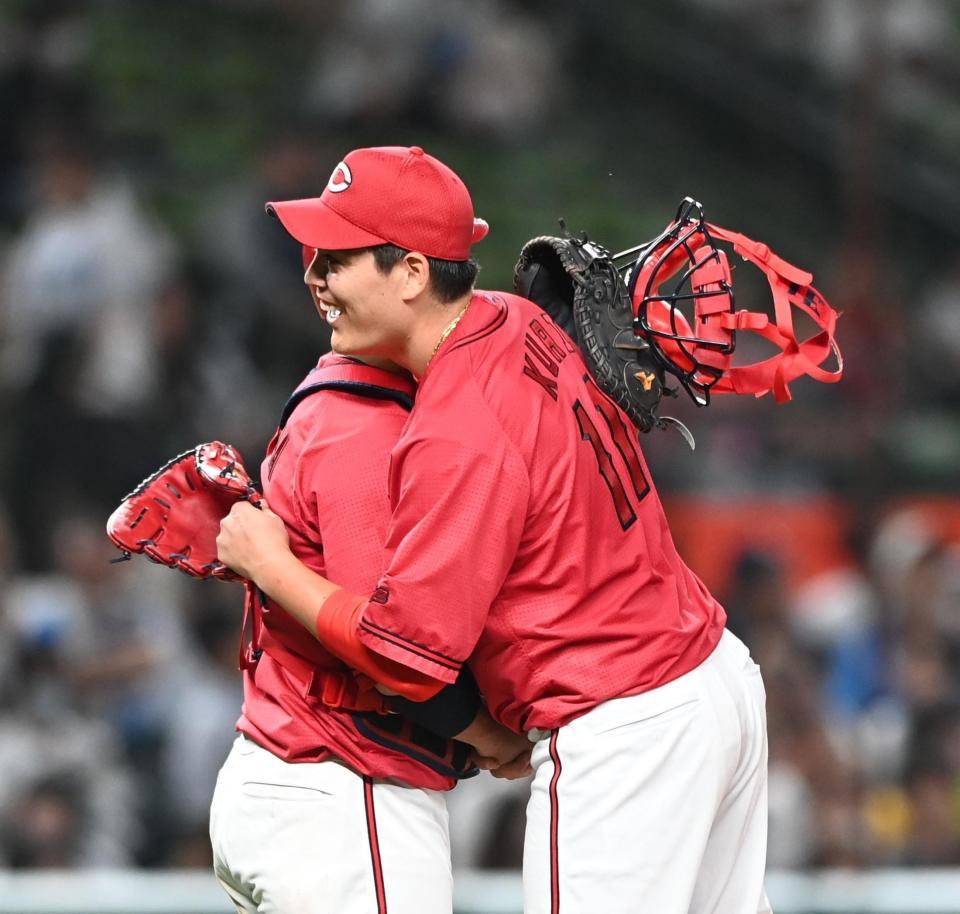 　完封勝利を挙げ、坂倉と抱き合って喜ぶ九里（撮影・園田高夫）