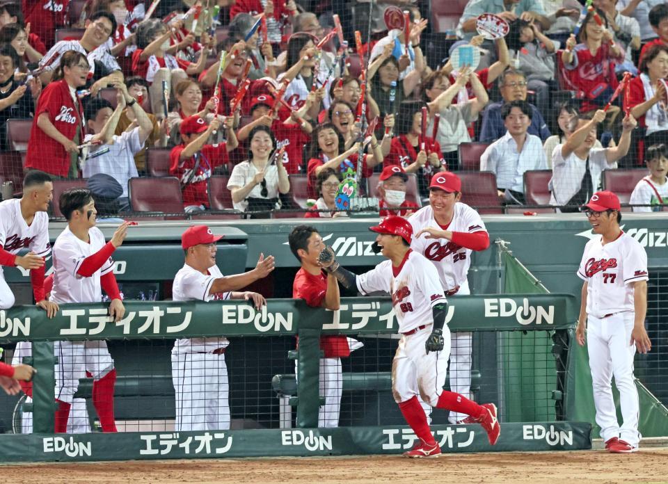 　８回、ワイルドピッチで勝ち越しの生還を果たした羽月（６９）を祝福する新井監督（右から２人目）ら（撮影・立川洋一郎）