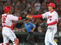 　９回を締めた栗林は石原と握手を交わす（撮影・市尻達拡）