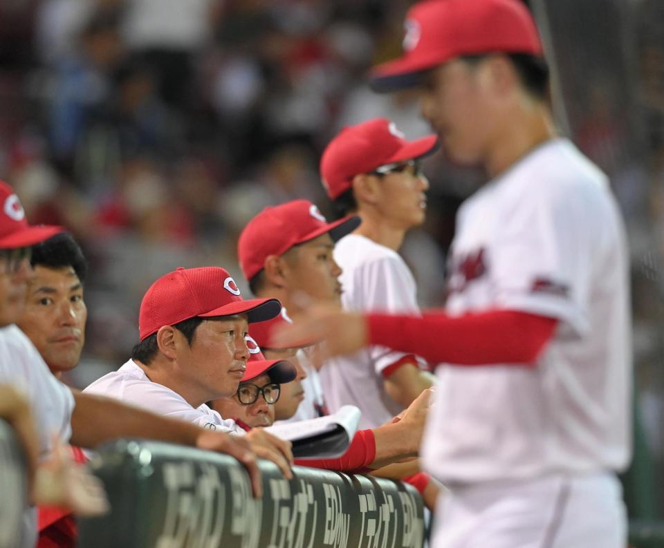 　８回、グラウンドを見つめる新井監督。右は交代を告げられた黒原（撮影・市尻達拡）