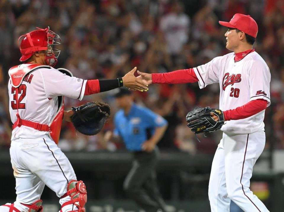 　９回を締めた栗林は石原と握手を交わす（撮影・市尻達拡）