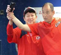 　河内広報（右）とじゃれ合う新井監督（撮影・西岡正）