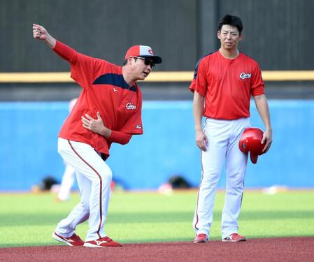 　野間（右）に身ぶり手ぶりでアドバイスする新井監督（撮影・佐藤厚）