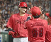 　４回、坂倉に中前適時打で生還しナインに迎えられる末包（撮影・金田祐二）