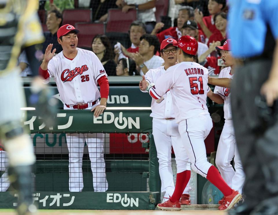 　７回、菊池の左犠飛で生還した小園（５１）を迎える新井監督（左）＝撮影・立川洋一郎