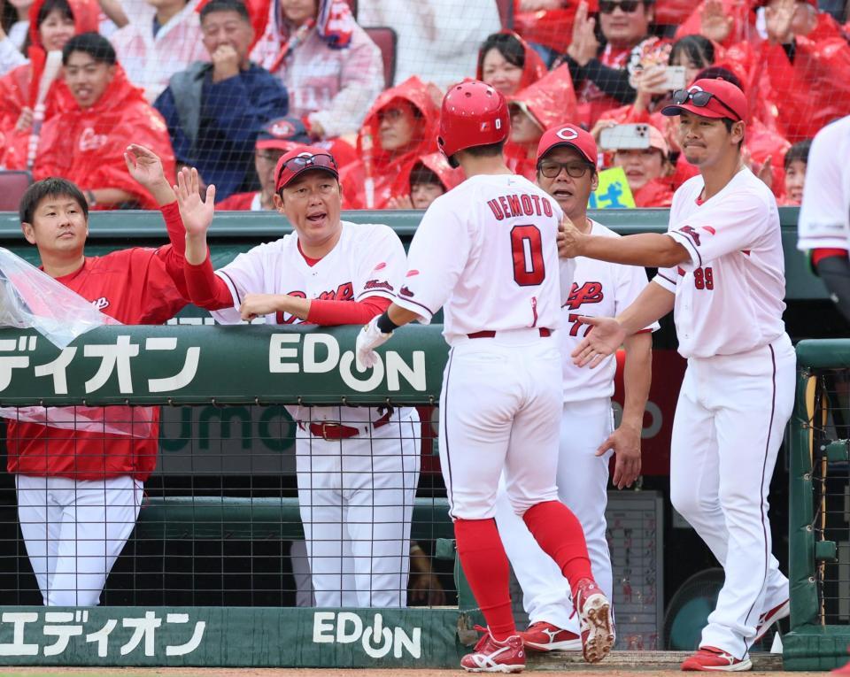 　６回、秋山の適時打で生還した上本（０）を迎える新井監督（中央）＝撮影・立川洋一郎