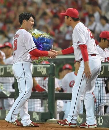 　現役引退登板を終えた野村は笑顔で新井監督と握手をする（撮影・市尻達拡）