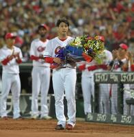 　現役引退登板を終えた野村は花束を手にファンにあいさつする（撮影・市尻達拡）