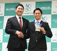 　１位指名あいさつの訪れた新井監督と笑顔で握手する佐々木泰（右）＝撮影・園田高夫