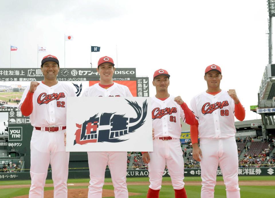 　来季のキャッチフレーズ「遮二無二」のボードを披露する（左から）末包、堂林、矢野、田村