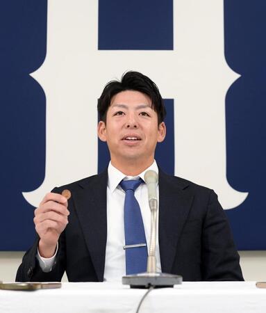 契約更改交渉後の会見で、席に着き１０円球を見せる野間（撮影・市尻達拡）