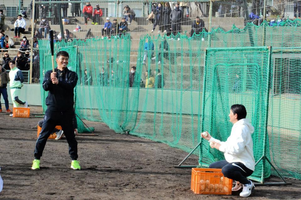 　小林（右）にボールを上げてもらって打撃の実演をする中村奨（撮影・畠山賢大）