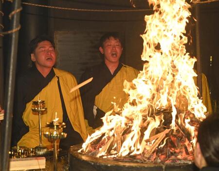 　火柱の前で経を唱える会沢（左）と堂林（撮影・市尻達拡）