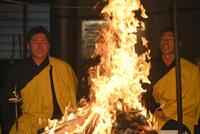 　火柱の前で経を唱える会沢（左）と中村奨（撮影・市尻達拡）