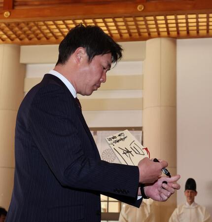 　絵馬に「日本一」と書き記す新井監督（撮影・市尻達拡）