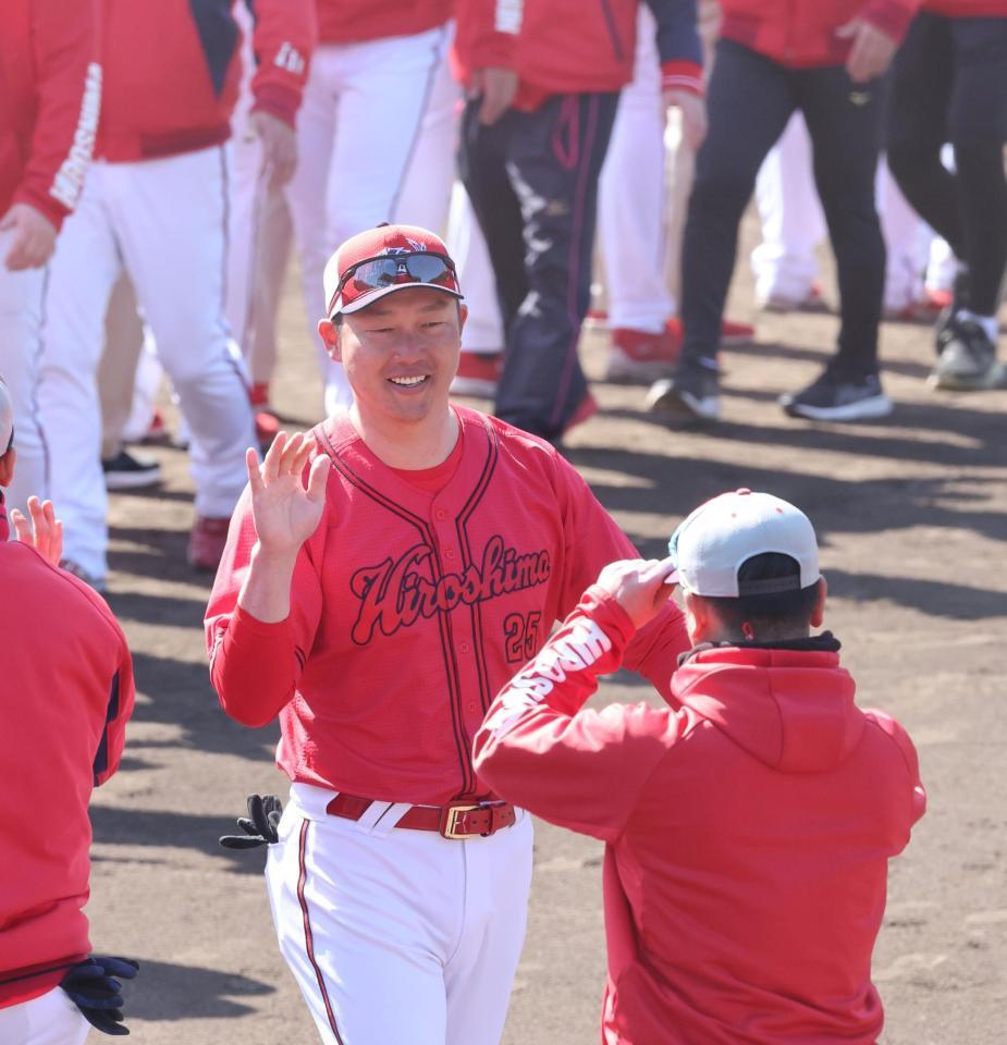 　日南でのキャンプを終え、選手やスタッフらとタッチを交わす新井監督（撮影・市尻達拡）