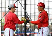 　ブルペンで投球練習を終えた佐藤柳（左）は渡辺とグラブタッチする（撮影・山口登）