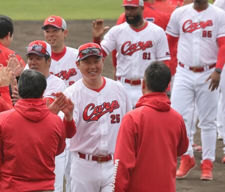 　沖縄でのキャンプを終え、選手、スタッフらとタッチを交わす新井監督（撮影・市尻達拡）