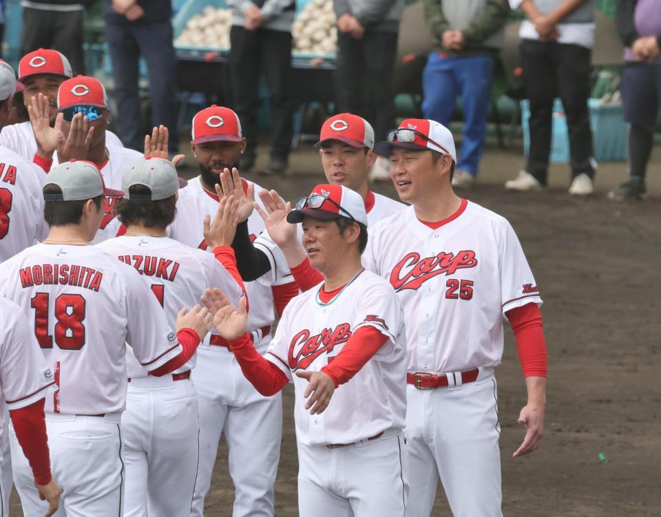 　沖縄でのキャンプを終え、選手、スタッフらとタッチを交わす新井監督（撮影・市尻達拡）