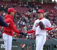 　オープン戦初登板を、１回無失点で終え、秋山（左）とタッチを交わす栗林（撮影・市尻達拡）