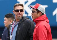 　エルドレッド駐米スカウト（左）と話す新井監督（撮影・佐々木彰尚）