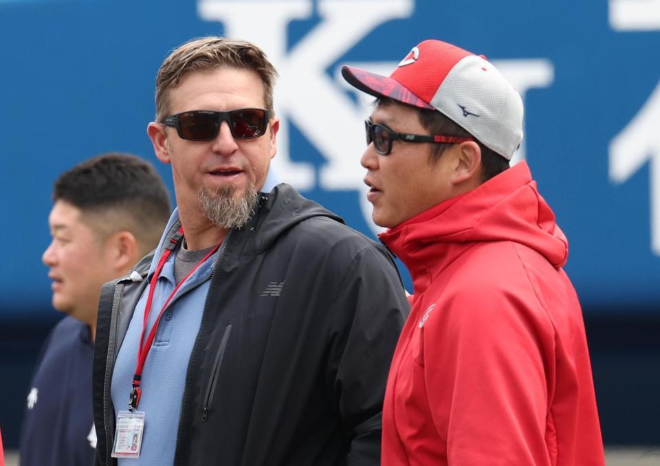 　エルドレッド駐米スカウト（左）と話す新井監督（撮影・佐々木彰尚）