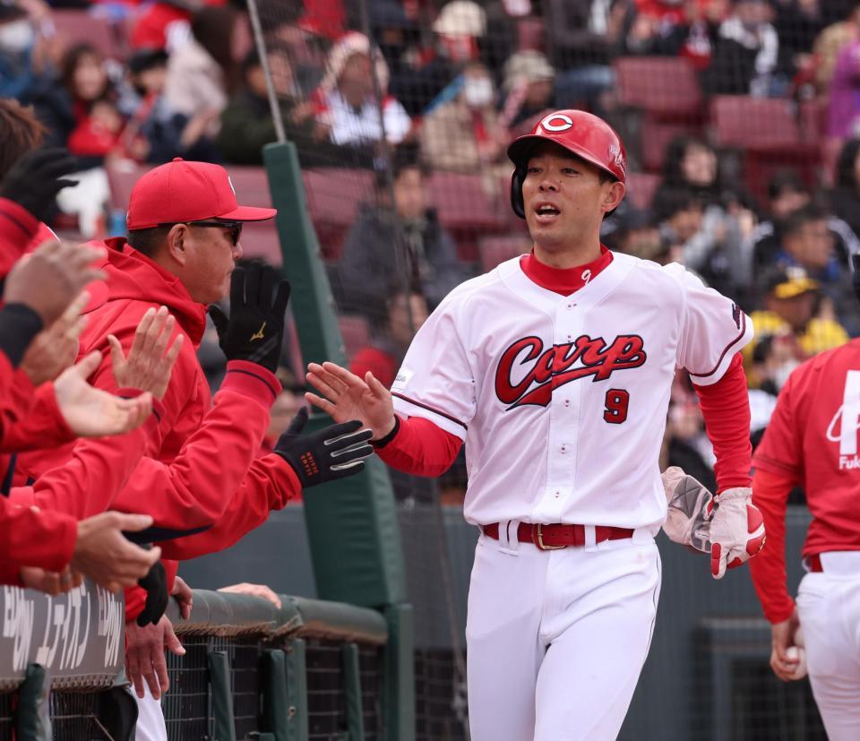 　４回、先制の本塁を駆け抜け、ナインとタッチを交わす秋山＝３０日