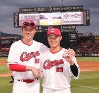 プロ１号の記念球を手に、新井監督（左）と記念撮影に応じる田村（撮影・市尻達拡）