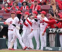 ９回、送りバントを決め、ナインに出迎えられる二俣翔一（撮影・市尻達拡）