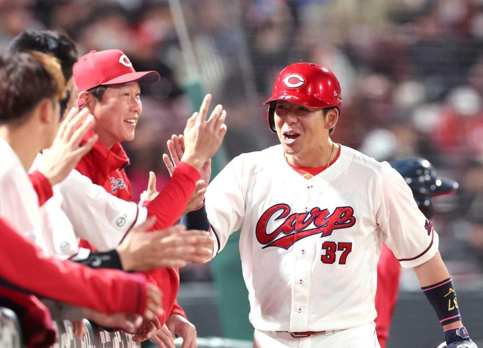 　４回、生還した野間と、タッチを交わす新井監督（撮影・市尻達拡）