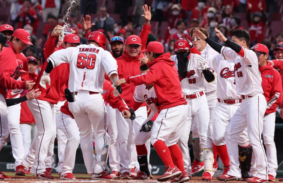 　１１回、プロ１号となるサヨナラソロを放ち、ナインが待つ輪に飛び込む田村（撮影・市尻達拡）