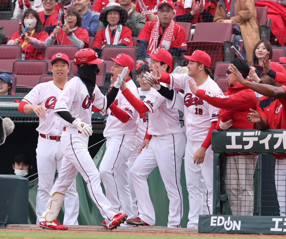 ９回、送りバントを決め、ナインに出迎えられる二俣翔一（撮影・市尻達拡）