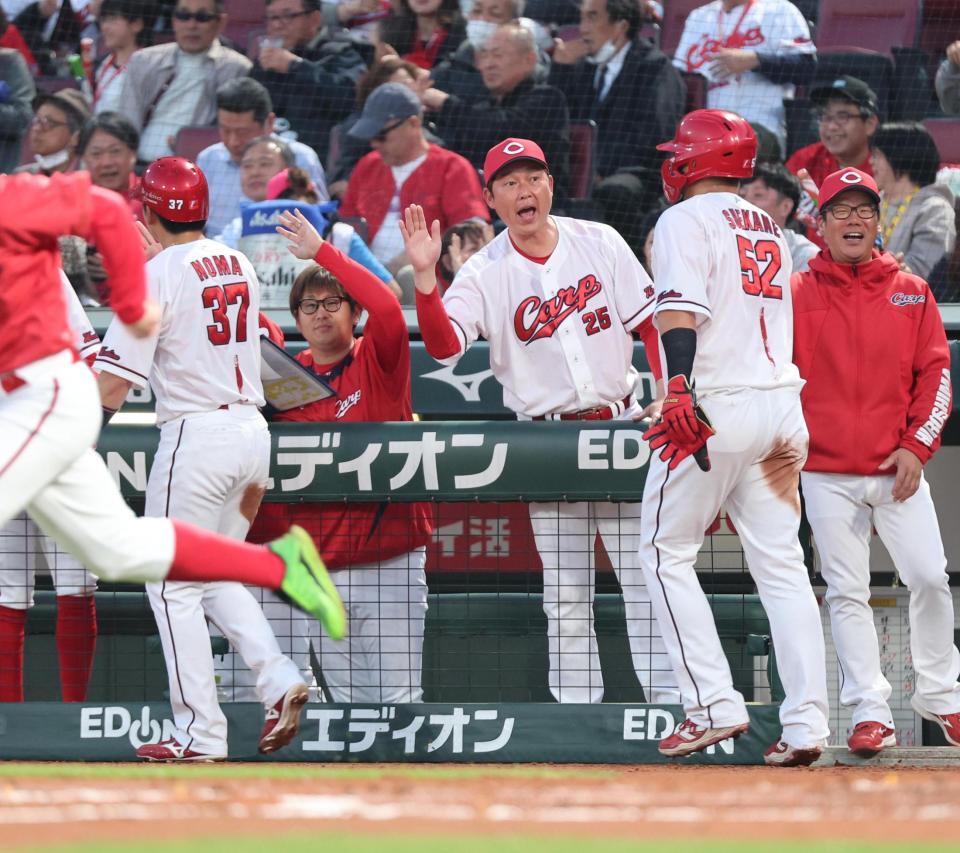 　２回、菊池の適時打で生還した二走野間（３７）、三走末包（５２）を迎える新井監督（中央）