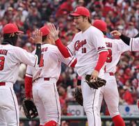 　今季初勝利を完封で飾り、チームメートとタッチを交わす床田（撮影・市尻達拡）